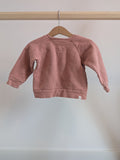 Grey pyjama set with black cat patterns, featuring long sleeves and pants, hanging on a wooden hanger.